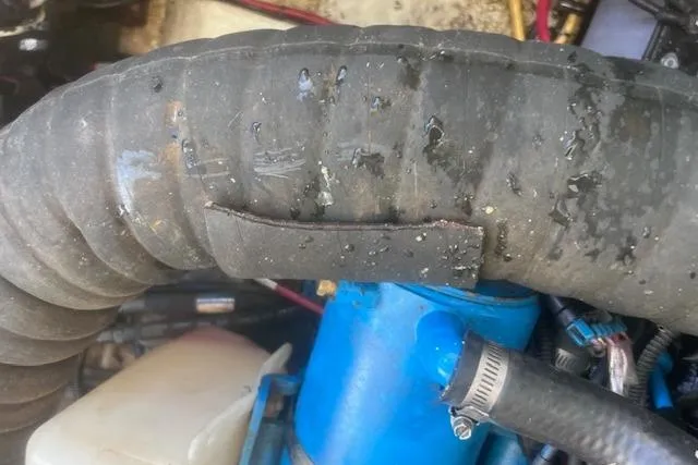 Slide: The Image of Close-up of a 2003 Pursuit 3000 Express engine hose with visible wear and moisture. - 38
