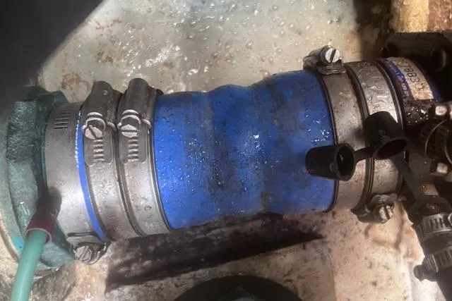 Slide: The Image of Close-up of a blue hose with metal clamps on a 2003 Pursuit 3000 Express boat. - 39