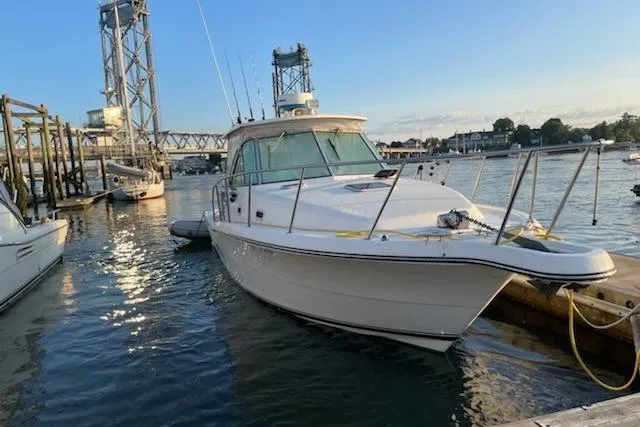 Slide: The Image of 2003 Pursuit 3000 Express boat docked in a marina at sunset. - 7