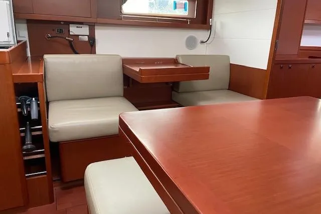 Slide: The Image of Interior of 2018 Beneteau Oceanis 45 yacht with wooden dining area and beige seating. - 35