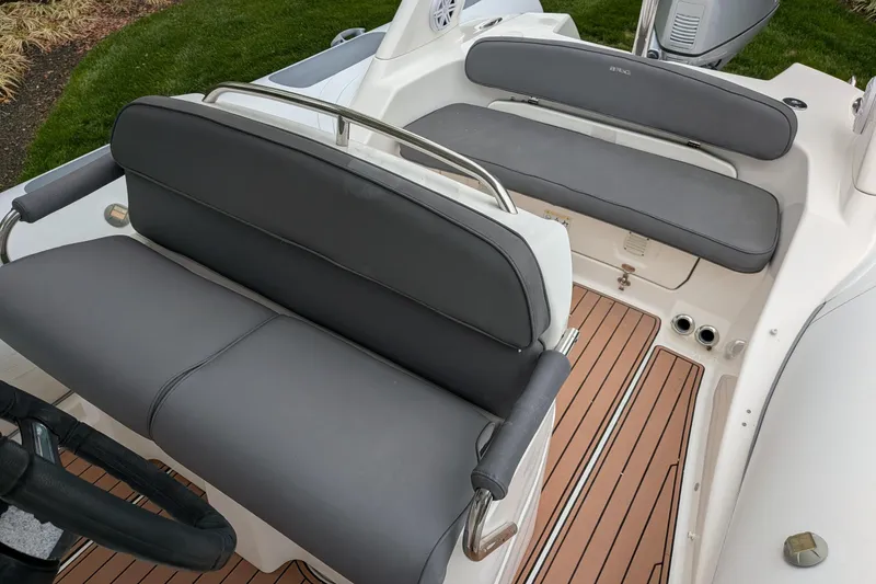 Slide: The Image of 2016 Brig E780 boat interior with gray seating and teak-style flooring. - 11