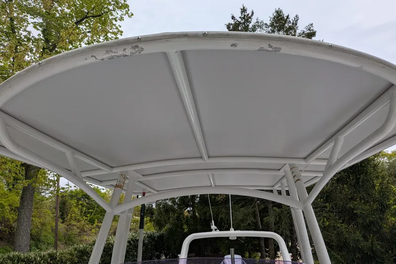 Slide: The Image of 2016 Brig E780 boat canopy with visible wear, surrounded by trees. - 14