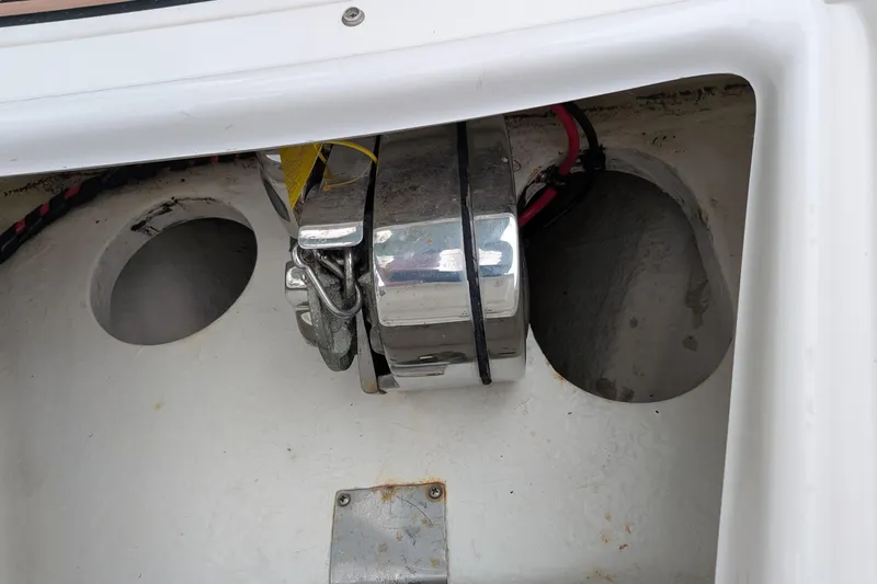 Slide: The Image of Storage compartment of a 2016 Brig E780 boat with visible wiring and metal components. - 16
