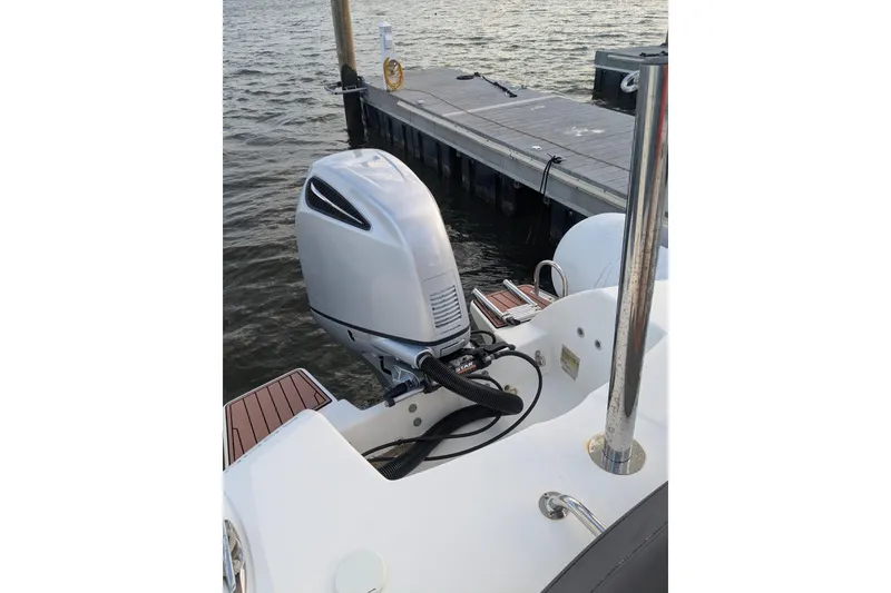 Slide: The Image of 2016 Brig E780 boat with outboard motor docked by the water. - 18