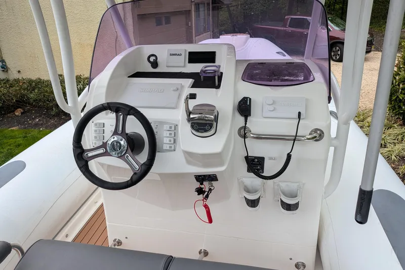 Slide: The Image of 2016 Brig E780 boat dashboard with steering wheel, controls, and navigation equipment. - 5