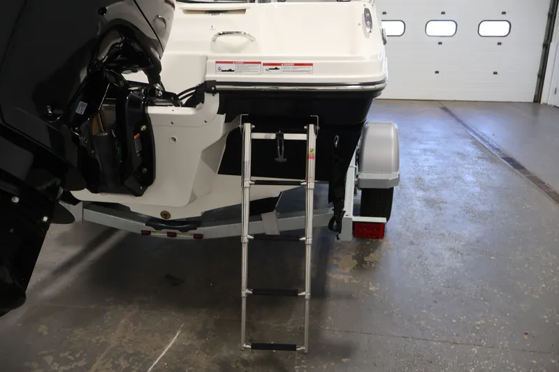Slide: The Image of 2026 Bayliner VR4 Bowrider OB with ladder and outboard motor in a garage. - 34