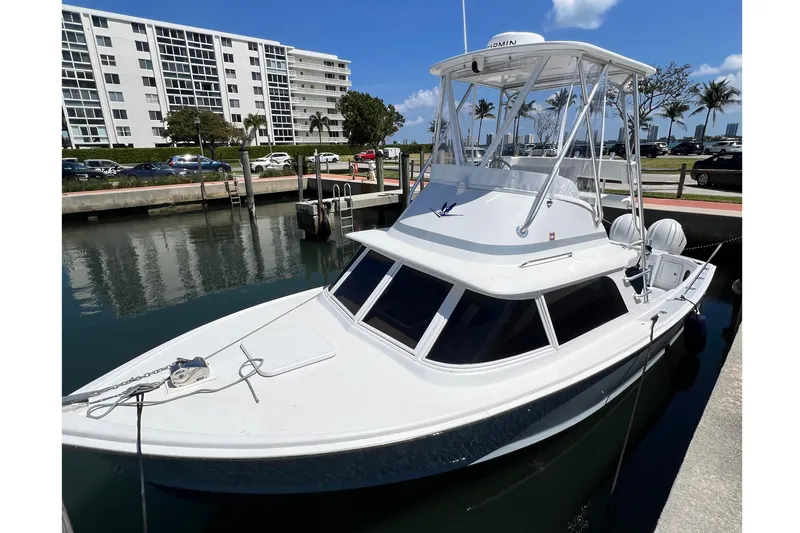 The Image of 1973 Bertram 31 Flybridge Cruiser docked near waterfront buildings. - 1