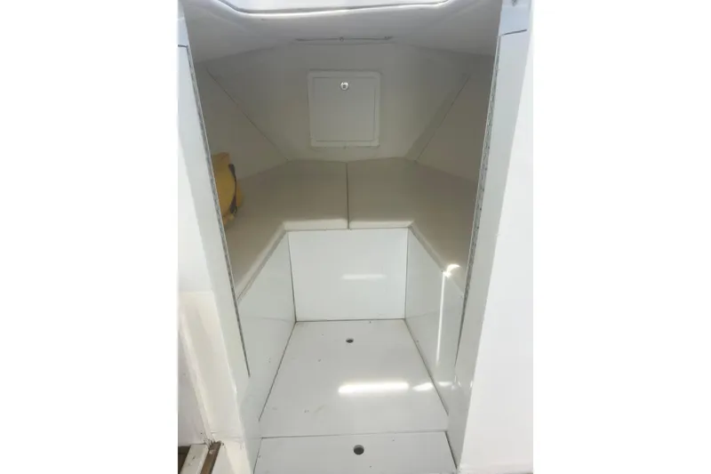Slide: The Image of 1973 Bertram 31 Flybridge Cruiser cabin interior, featuring a compact, white space. - 27