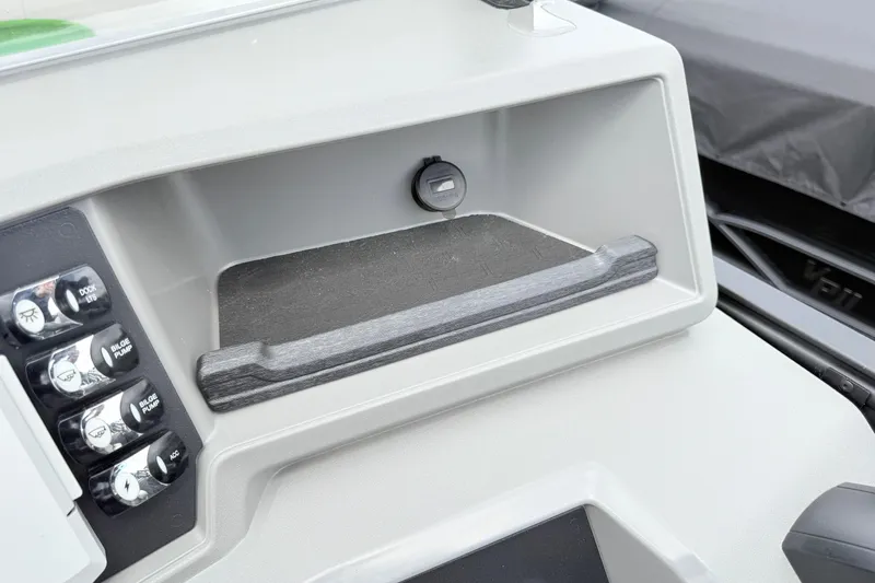 Slide: The Image of Control panel of 2026 Qwest E-Class RLS 18 boat with switches and storage compartment. - 19