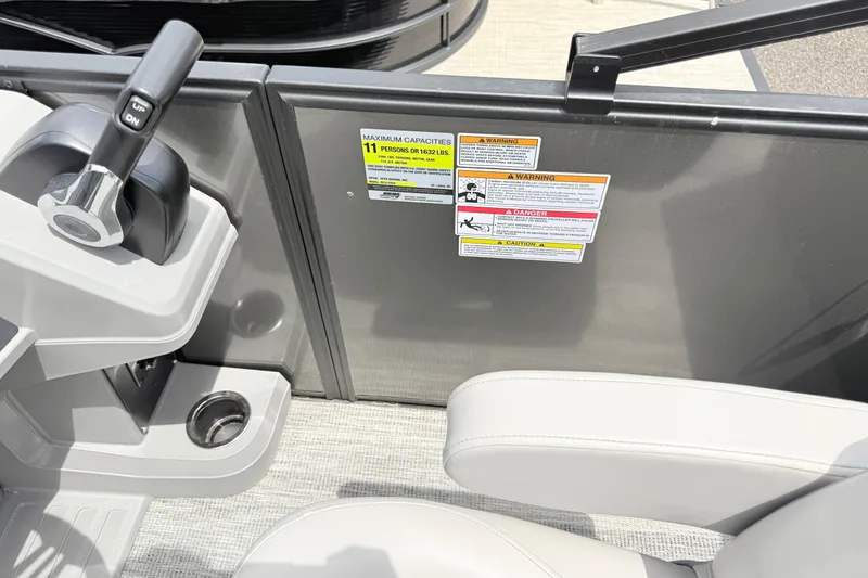 Slide: The Image of Control panel and seating of 2026 Qwest E-Class RLS 18 boat with safety labels. - 7