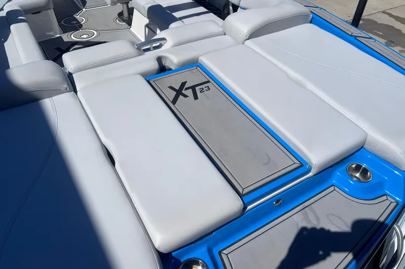Slide: The Image of 2021 MasterCraft XT23 boat interior with gray seating and blue accents. - 11