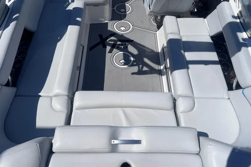 Slide: The Image of 2021 MasterCraft XT23 boat interior with sleek white seating and modern design. - 12