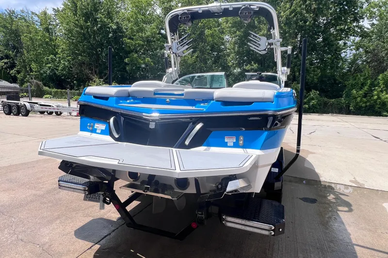 Slide: The Image of 2021 MasterCraft XT23 boat with blue and white exterior, parked on a concrete surface. - 5