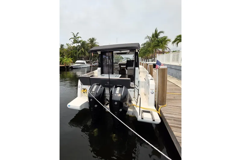 Slide: The Image of 2025 Jeanneau NC 895 Series 2 docked, featuring dual outboard engines and sleek design. - 12