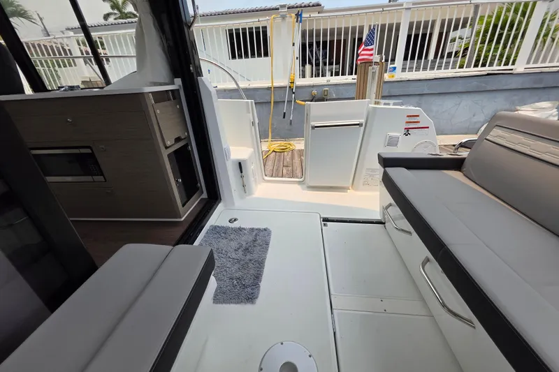 Slide: The Image of Interior view of 2025 Jeanneau NC 895 Series 2 boat, featuring seating and storage. - 16