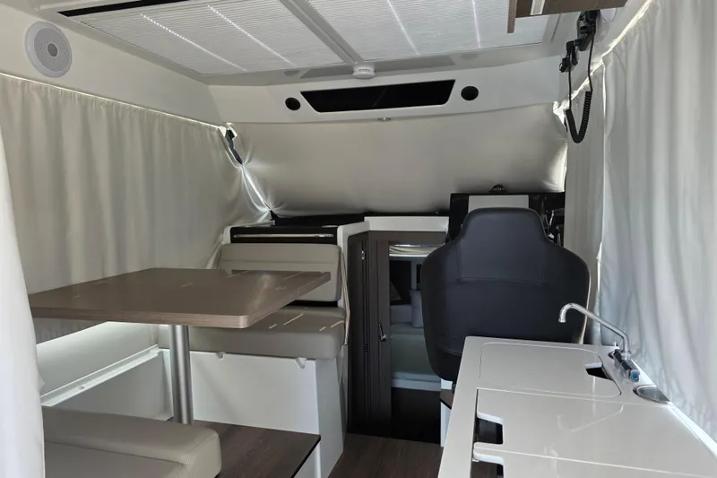 Slide: The Image of Interior of 2025 Jeanneau NC 895 Series 2 boat, featuring seating, table, and kitchenette. - 22