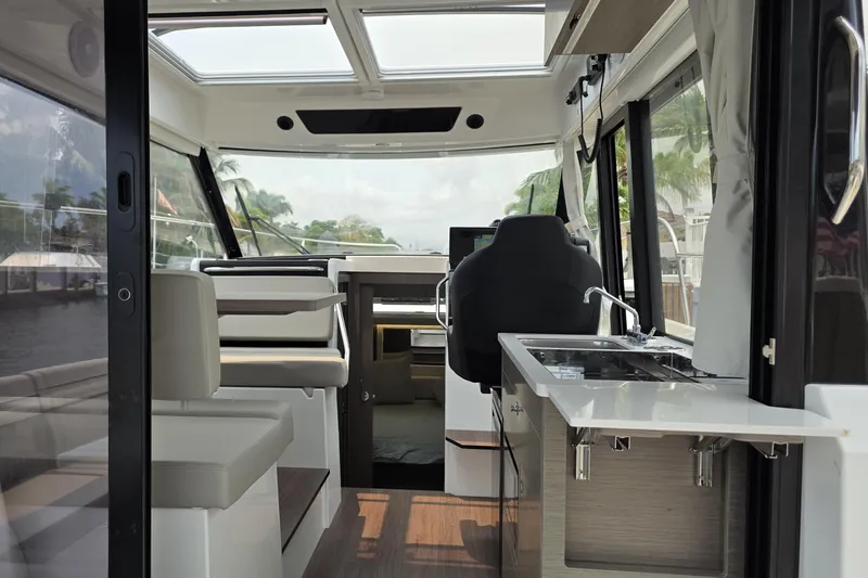 Slide: The Image of Interior view of 2025 Jeanneau NC 895 Series 2 boat, featuring modern seating and kitchenette. - 23