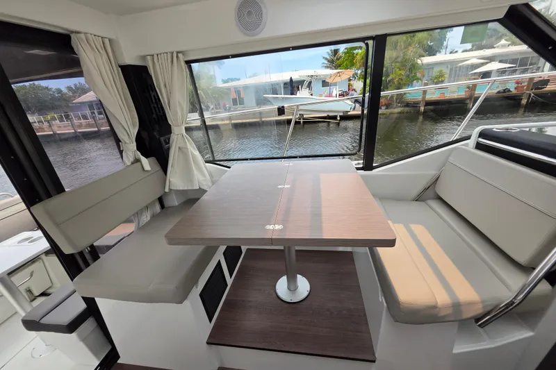 Slide: The Image of Interior of 2025 Jeanneau NC 895 Series 2 boat with dining area and waterfront view. - 28
