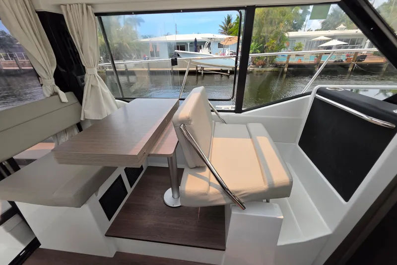Slide: The Image of Interior of 2025 Jeanneau NC 895 Series 2 boat with dining area and waterfront view. - 29