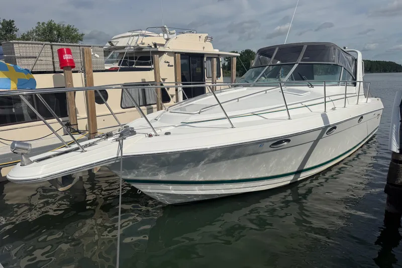 The Image of 1999 Formula 34 Performance Cruiser docked at marina, featuring sleek white design and spacious deck. - 0