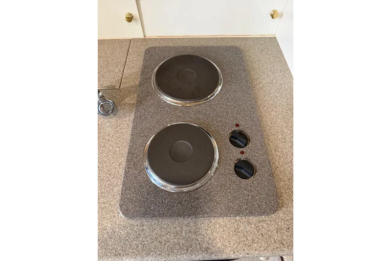 Slide: The Image of Electric stove on 1999 Formula 34 Performance Cruiser, featuring dual burners and control knobs. - 26