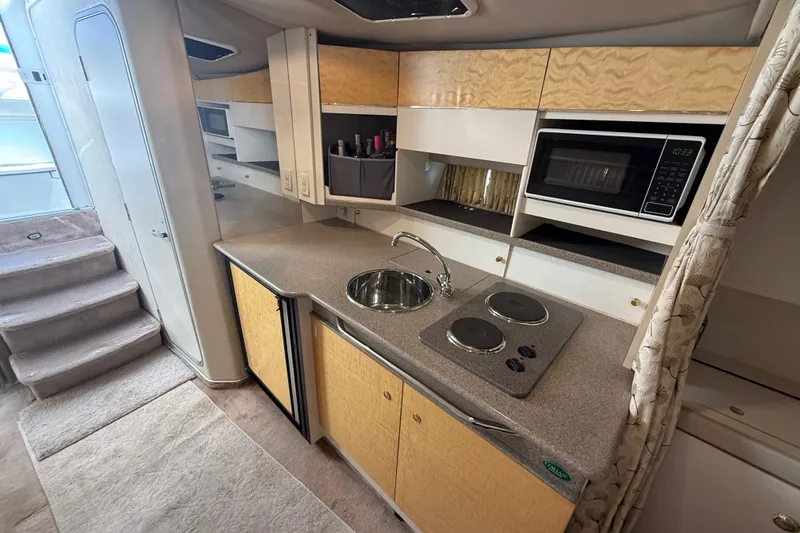 Slide: The Image of Interior of a 1999 Formula 34 Performance Cruiser, featuring a compact kitchen with modern amenities. - 28