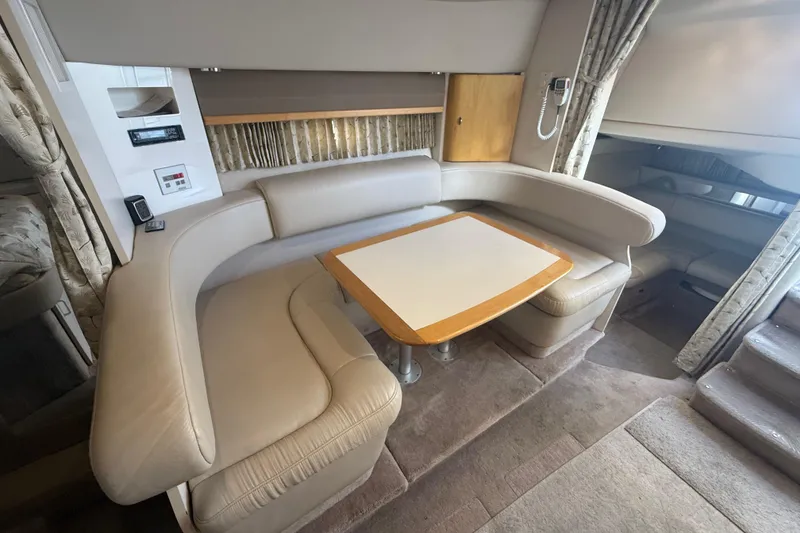 Slide: The Image of 1999 Formula 34 Performance Cruiser interior with beige seating and wooden table. - 29
