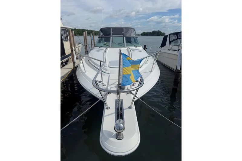 Slide: The Image of 1999 Formula 34 Performance Cruiser docked with Swedish flag, under a partly cloudy sky. - 3