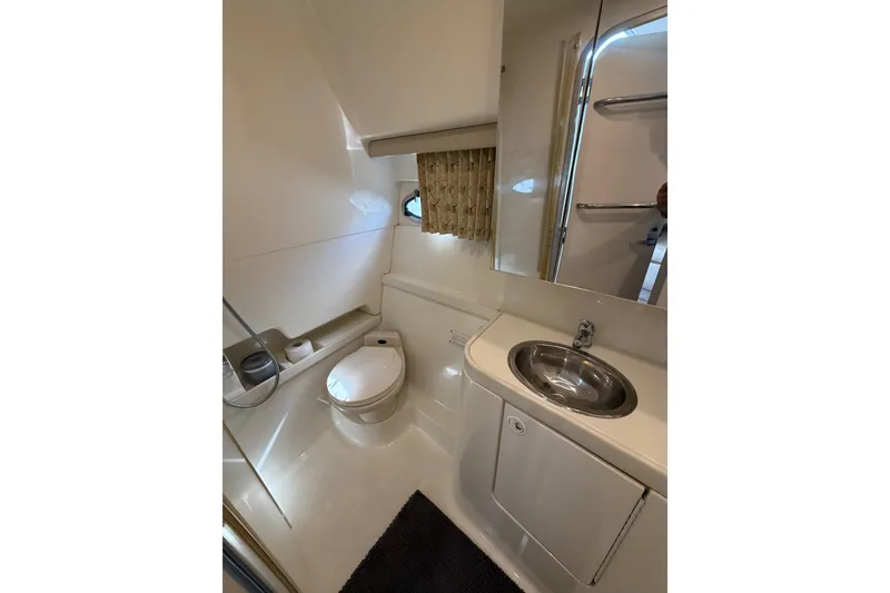 Slide: The Image of 1999 Formula 34 Performance Cruiser bathroom with toilet, sink, and mirror. - 38