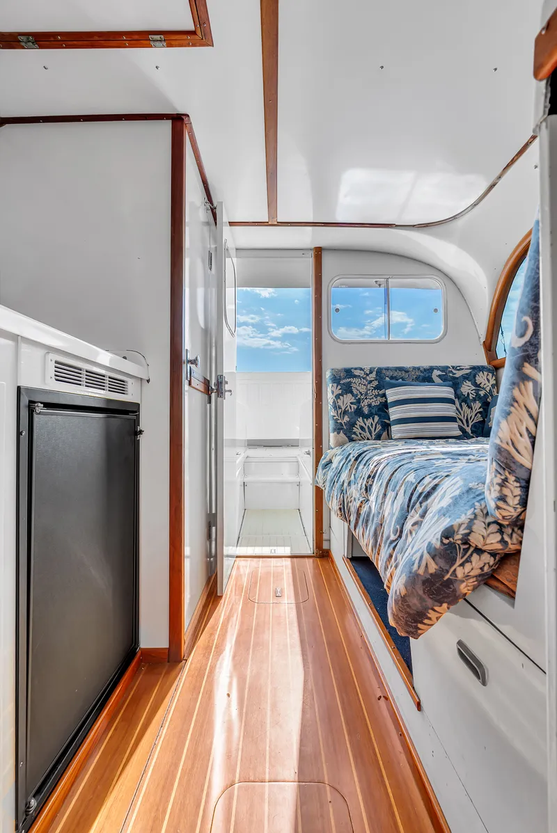 Slide: The Image of Interior of a 1979 Bertram Flybridge Cruiser with wooden flooring and blue upholstery. - 19