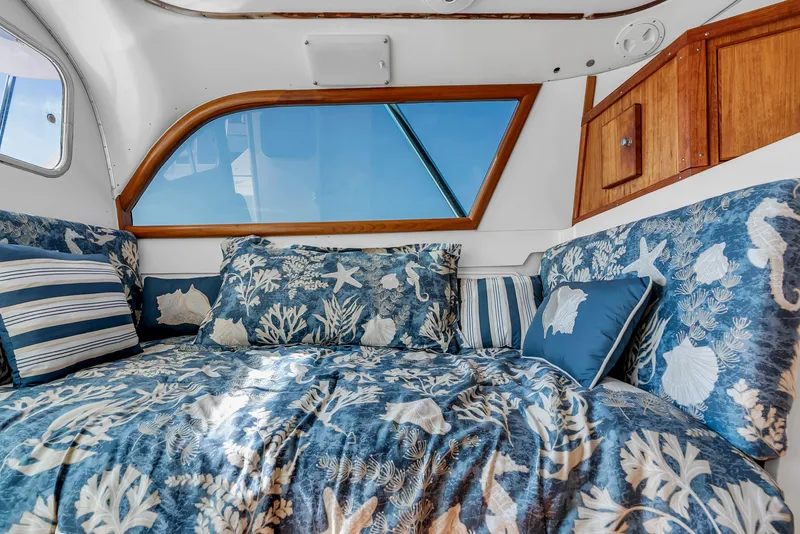 Slide: The Image of Interior of a 1979 Bertram Flybridge Cruiser with nautical bedding and wooden accents. - 23