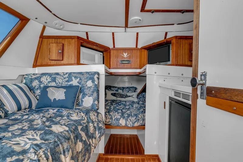 Slide: The Image of Interior of the 1979 Bertram Flybridge Cruiser with cozy beds and wood accents. - 24