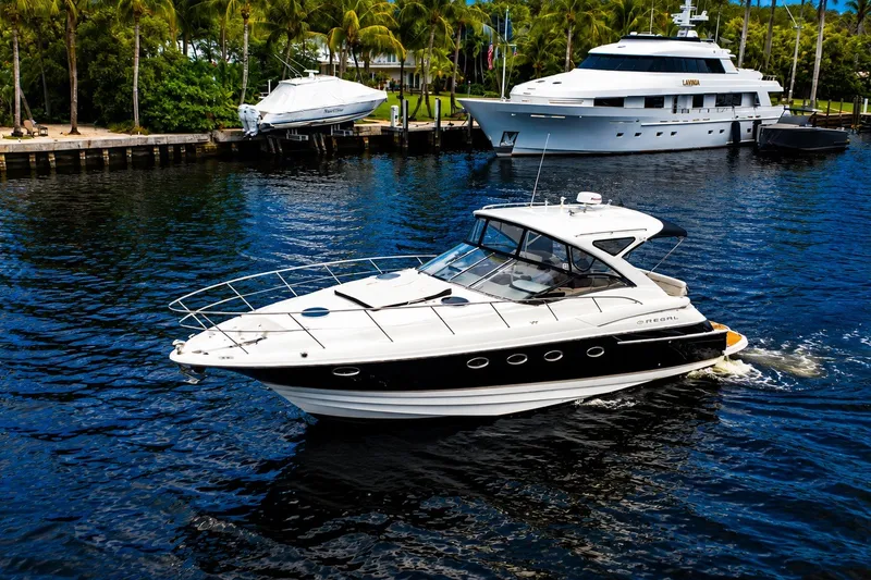 Slide: The Image of 2008 Regal Commodore 4460 yacht cruising on a serene waterway, surrounded by lush palm trees. - 5