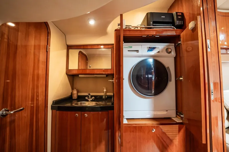 Slide: The Image of Luxurious 2008 Regal Commodore 4460 yacht interior with washer, sink, and wooden cabinetry. - 56