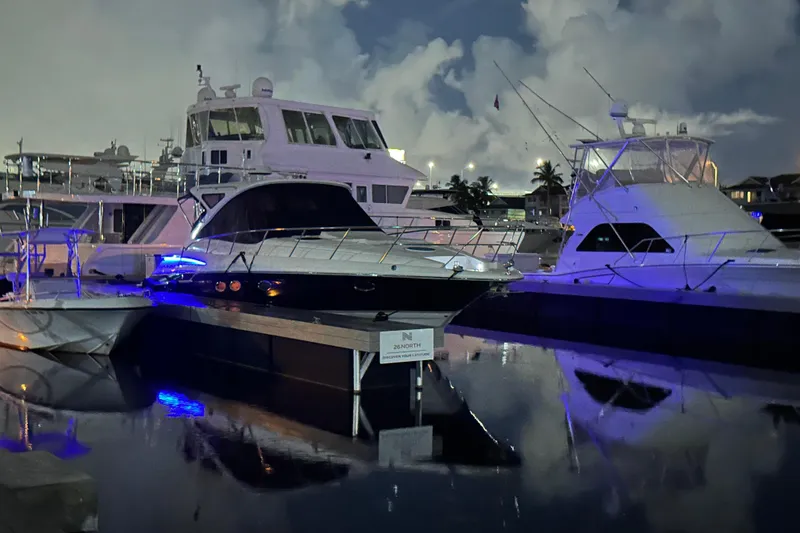 Slide: The Image of 2008 Regal Commodore 4460 yacht docked at night, illuminated by blue lights. - 3
