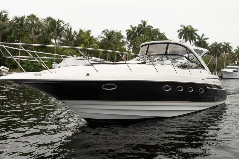 Slide: The Image of 2008 Regal Commodore 4460 yacht on water, surrounded by palm trees. - 16