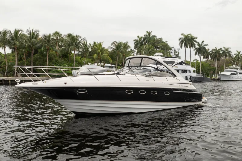 Slide: The Image of 2008 Regal Commodore 4460 yacht on water, surrounded by palm trees and other boats. - 20
