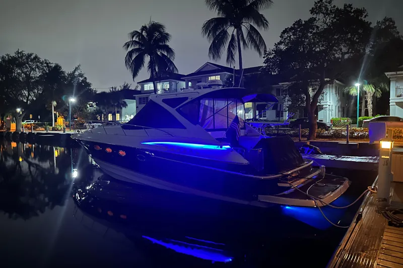 Slide: The Image of 2008 Regal Commodore 4460 yacht docked at night, illuminated by blue lights. - 4
