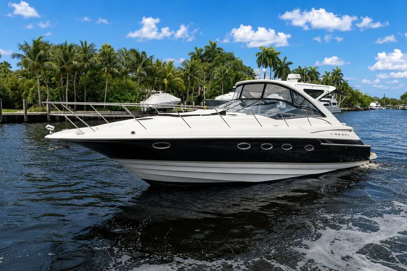 Slide: The Image of 2008 Regal Commodore 4460 yacht cruising on a scenic waterway with palm trees. - 3
