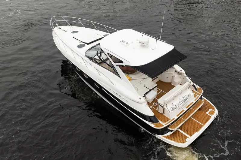 Slide: The Image of 2008 Regal Commodore 4460 yacht cruising on dark water, aerial view. - 12