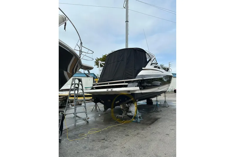 Slide: The Image of 2008 Regal Commodore 4460 yacht on stands, covered, with ladder nearby. - 5