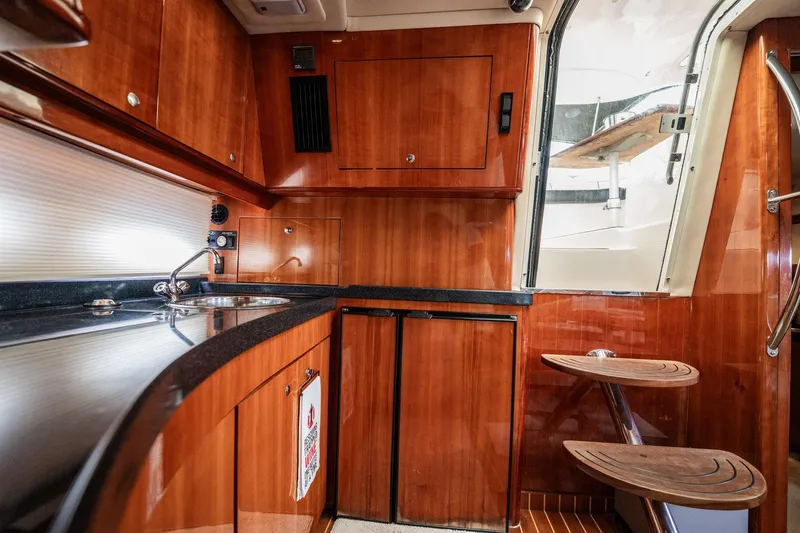 Slide: The Image of Luxurious 2008 Regal Commodore 4460 yacht interior with sleek wooden cabinetry and modern amenities. - 68