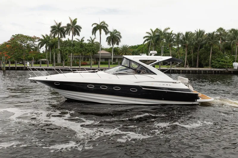 Slide: The Image of 2008 Regal Commodore 4460 yacht cruising on a scenic waterway with palm trees. - 7