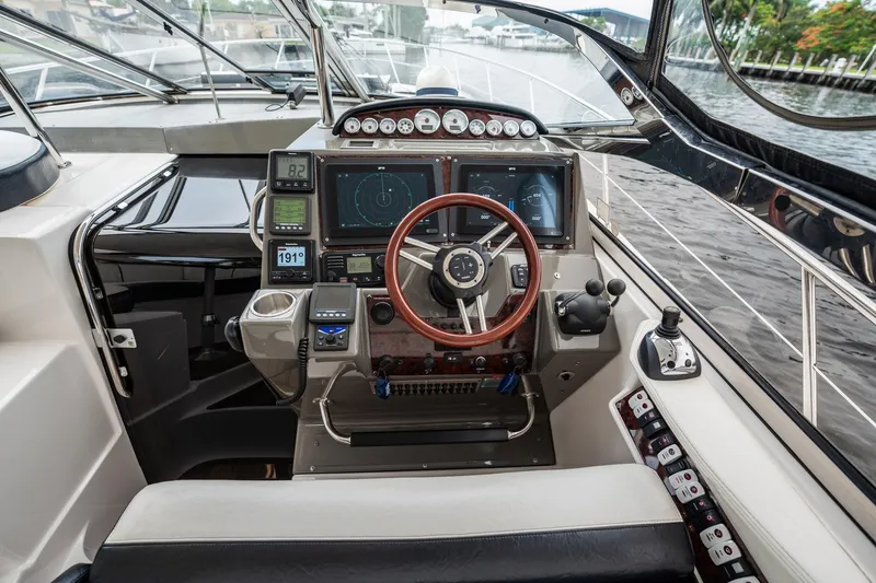 Slide: The Image of Cockpit of 2008 Regal Commodore 4460 yacht with advanced navigation controls and steering wheel. - 82
