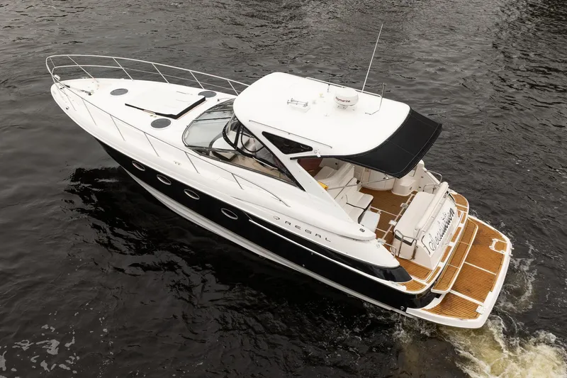 Slide: The Image of 2008 Regal Commodore 4460 yacht cruising on water, featuring sleek design and spacious deck. - 11