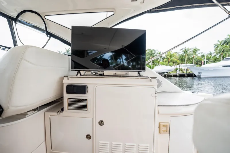 Slide: The Image of Luxury yacht interior with TV, Regal Commodore 4460, 2008 model, docked near palm trees. - 84