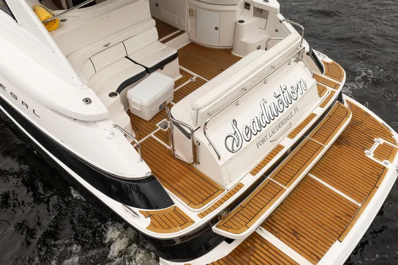 Slide: The Image of 2008 Regal Commodore 4460 yacht with teak deck, named "Seaduction," docked in Fort Lauderdale. - 10