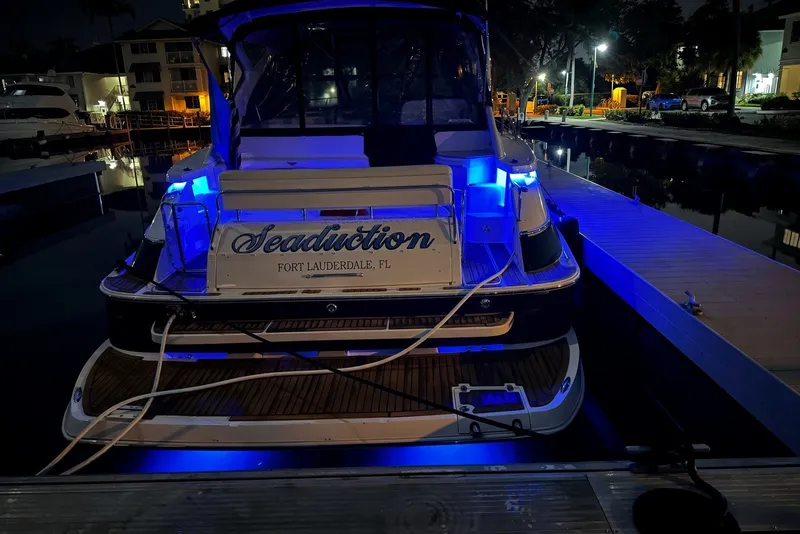 Slide: The Image of 2008 Regal Commodore 4460 yacht docked at night with blue LED lights. - 102