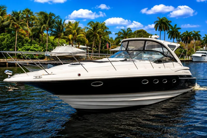 Slide: The Image of 2008 Regal Commodore 4460 yacht cruising on a tropical waterway with palm trees. - 4