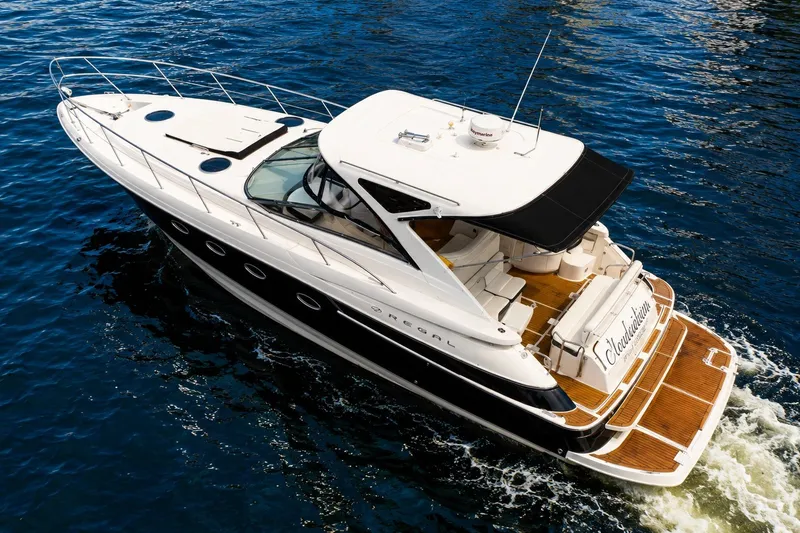 Slide: The Image of 2008 Regal Commodore 4460 yacht cruising on blue water, showcasing sleek design and luxury features. - 100